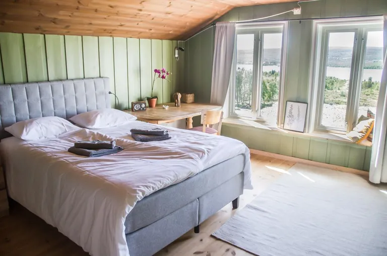 A renovated bedroom with panoramic views over the water and mountains
