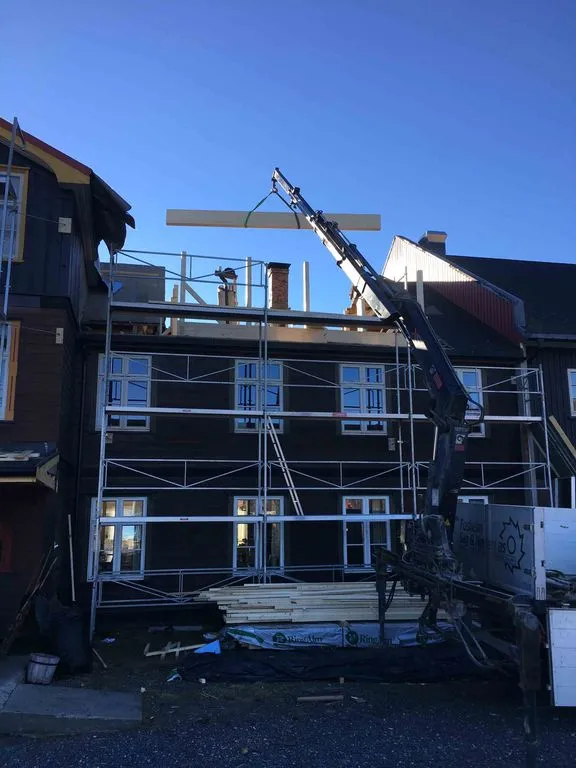 Construction underway at Nøsen, a crane lifting materials past the scaffolding
