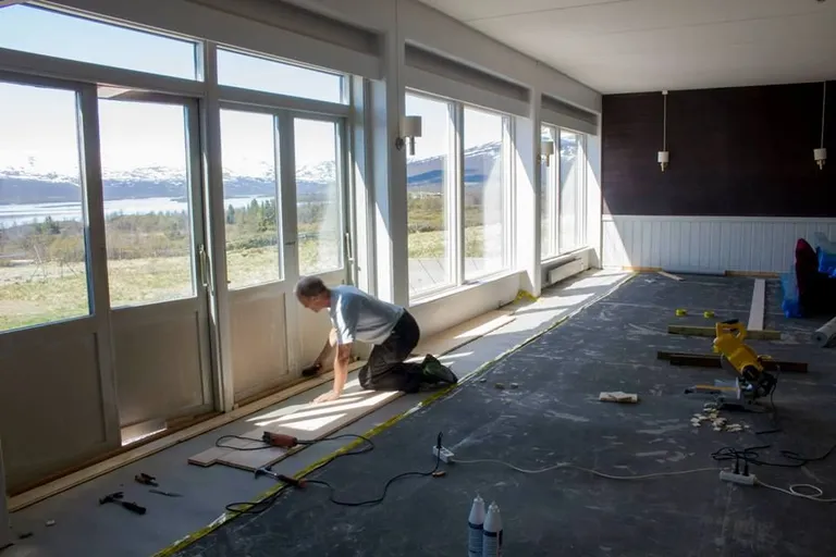 Laying new flooring during the renovation, with a view of the mountains and lake